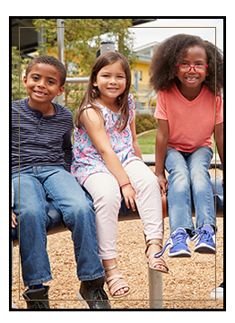 Three happy students sitting on a fence outside