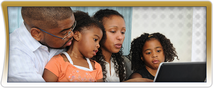 A family of four using a laptop together